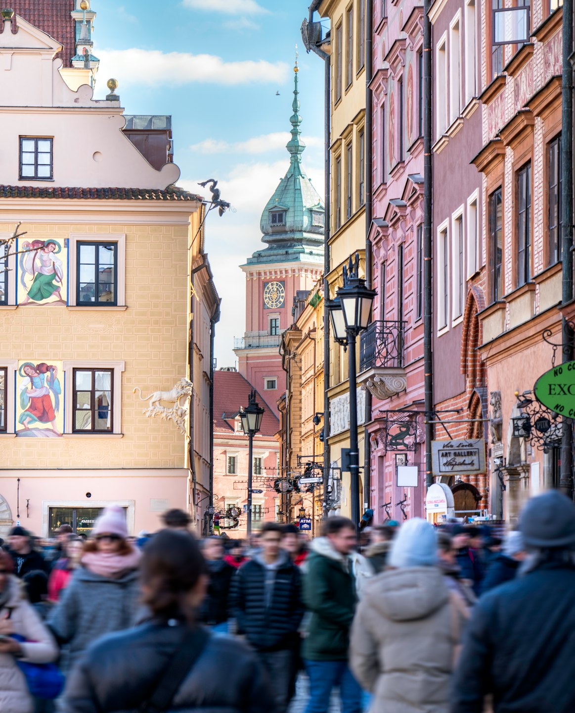 Tłum ludzi idący wąską europejską ulicą.