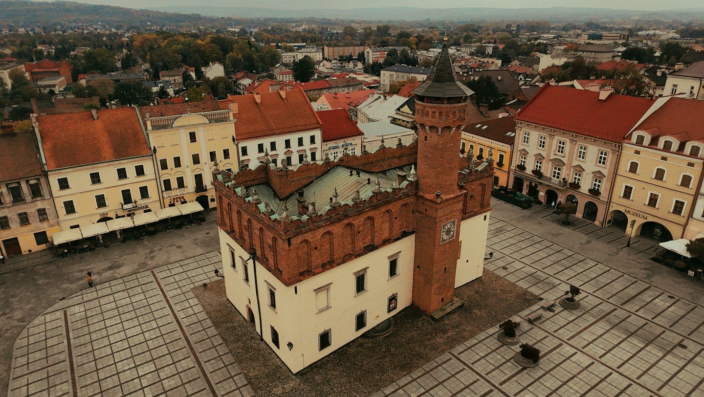 Samotna osoba przechodzi przez zabytkowy europejski rynek.